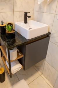 a bathroom with a white sink on a counter at Casa Centro de Guabiruba in Guabiruba +36 photos