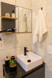 a bathroom with a white sink and towels at Casa Centro de Guabiruba in Guabiruba