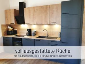 a kitchen with blue cabinets and a sink at Ferienhaus Inntal - Ferienwohnung Naunspitz - ruhig schlafen, zentral starten, beliebt bei Wanderern in Kiefersfelden +36 photos