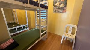 a small room with bunk beds and a chair at Newlives Transient 2 Hillside - 2nd Floor in Baguio