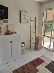 un salon blanc avec une échelle et une étagère dans l'établissement Satine Beige, à La Celle-sous-Gouzon