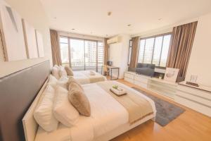 een grote slaapkamer met 2 bedden en een flatscreen-tv bij Executive Suite 2 Beds Nana BTS 5 mins in Bangkok +14 foto's