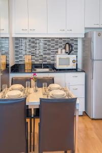 een keuken met een tafel met stoelen en een magnetron bij Executive Suite 2 Beds Nana BTS 5 mins in Bangkok