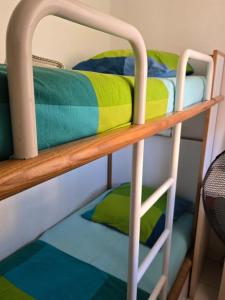 un lit superposé avec des couvertures colorées sur la couchette inférieure dans l'établissement Satine Beige, à La Celle-sous-Gouzon