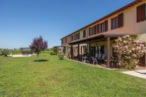 a building with a yard with chairs and flowers at La Sosta di Braccio in Macchie
