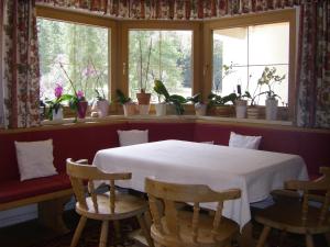 ゲルロスにあるHaus Lärchenbrunnのテーブル付きの部屋、鉢植えの植物のある窓