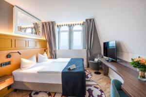 TV a/nebo společenská místnost v ubytování SEETELHOTEL Ostseehotel das Entdeckerhotel an der Ostsee und der perfekte Startpunkt für Ihre Inselabenteuer