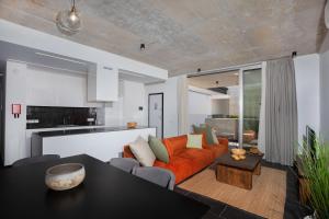 a living room with an orange couch and a table at Bridge House 301-3BR Penthouse in Limassol