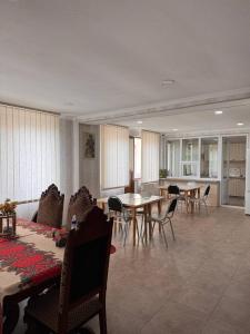 un soggiorno con tavoli e sedie e una cucina di Hotel forest echo a Borjomi