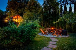 a picnic table and chairs in a garden at night at Osada u Beatki - Strefa SPA in Lutowiska