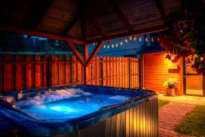 a large hot tub in a backyard at night at Osada u Beatki - Strefa SPA in Lutowiska