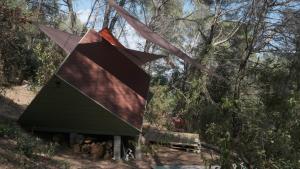 Una casa para pájaros colgada de un poste en el bosque. en Le Ptit Mas, en Salernes