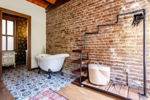 une salle de bain avec un mur de briques et une baignoire dans l'établissement Chic 2br Retreat House - Heart Of Cihangir! #394, à Istanbul 25 autres photos