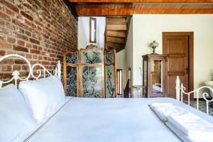 - un lit blanc dans une chambre dotée d'un mur en briques dans l'établissement Chic 2br Retreat House - Heart Of Cihangir! #394, à Istanbul