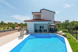 una villa con piscina frente a una casa en Villa Renči, en Buje