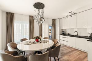 cocina blanca con mesa de comedor y sillas en Villa Renči, en Buje