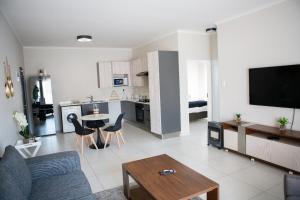 a living room with a couch and a table at Oasis Comfort Apartment in Midrand