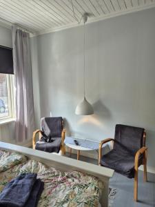 a bedroom with two chairs and a bed and a table at Lilla Kari in Varberg