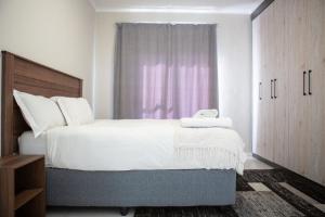 a bedroom with a large bed and a window at Oasis Comfort Apartment in Midrand +27 photos