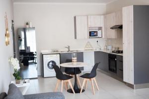 a kitchen with a table and chairs in a kitchen at Oasis Comfort Apartment in Midrand