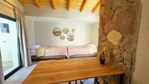 Cette chambre comprend 2 lits et une table en bois. dans l'établissement Los Olivos Purmamarca - Cabañas Boutique, à Purmamarca