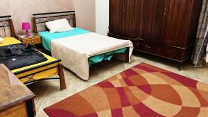 a bedroom with two beds and a table and a rug at Villa at Marassi in El Alamein