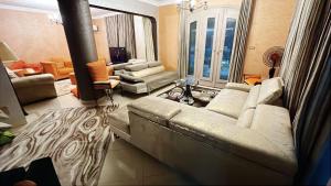 a living room with a large couch and a living room with at Villa at Marassi in El Alamein
