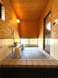 a bathroom with wooden walls and a wooden ceiling at UMIIE-小松浜-Private STAY in Miyazu