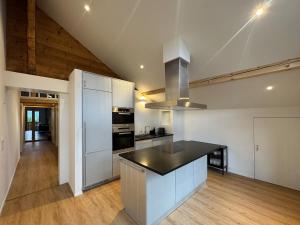 a kitchen with white appliances and a wooden floor at Des Alpes Sky Apartment in Beatenberg