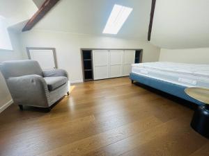 a bedroom with a bed and a chair in it at Квартира с террасой и видом на озеро в Стрезе in Stresa