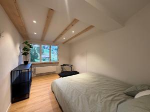 a bedroom with a large bed and a window at Des Alpes Sky Apartment in Beatenberg
