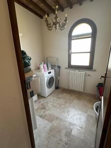 eine Waschküche mit einer Waschmaschine und einem Fenster in der Unterkunft Villa La Cava in Riparbella + 7 Fotos