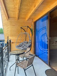 a porch with two chairs and a swing at RIVERSIDE Cottage in Martvili