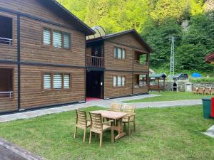 a table and chairs in front of a house at New toprak suite in Uzungöl