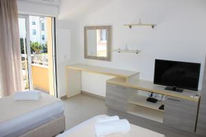 ein Zimmer mit einem Schreibtisch mit Fernseher und einem Bett in der Unterkunft Villa Velzon Guesthouse in Budva