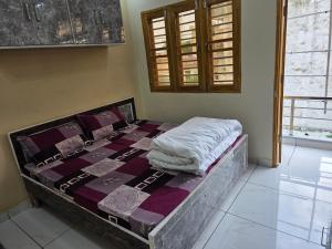 a bed in the corner of a room at Green Homestay in Bahādrābād