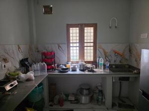 a kitchen with a sink and a counter top at Green Homestay in Bahādrābād +13 photos