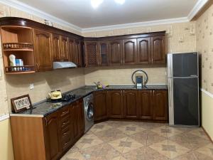 a kitchen with wooden cabinets and a stainless steel refrigerator at Qabala in Mekhrably