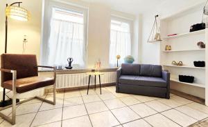 un salon avec un canapé et une chaise dans l'établissement 5 Minuten zur historischen Altstadt gemütliche Ferienwohnung in Trier Heilig-Kreuz, à Trèves