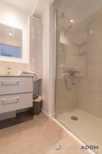 Un baño blanco con ducha y lavabo. en L'Amiral -500m Plage des Carrés- Parking, en La Bernerie-en-Retz