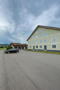 a black car parked in front of a large building at SMS-Homes I Auszeit am See #2 in Waltenhofen
