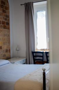 a bedroom with a bed and a window with a chair at Corte Santa Maria B&B in Vasto