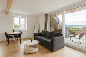a living room with a couch and a table at SMS-Homes I Auszeit am See #1 in Waltenhofen +3 photos
