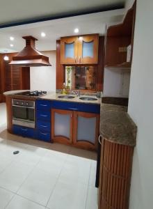 cocina con armarios azules y fogones en Cozy 2BR Apartment Near Sambil Valencia, en Naguanagua