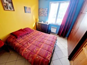 a bedroom with a red bed and a window at Cozy 2 bedroom house in Sars-Poteries