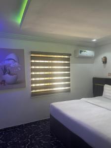una camera da letto con un letto e una finestra di Demayafolo suite a Gwarinpa