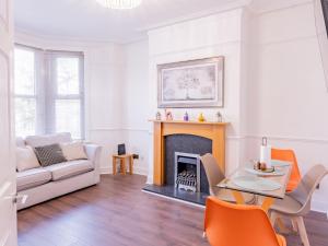 ウェストクリフ・オン・シーにあるPass the Keys Comfortable Flat with Patio Sleeps 4のソファと暖炉のあるリビングルーム