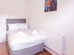 ウェストクリフ・オン・シーにあるPass the Keys Comfortable Flat with Patio Sleeps 4のベッドとタオル2枚のある寝室