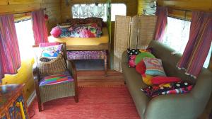 sala de estar con sofá y cama en Roulotte Mariposa, en Loches