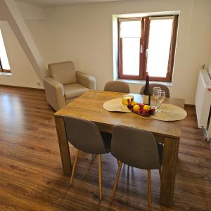 tavolo da pranzo con cesto di frutta e bottiglia di vino di Apartamenty Tadeusza Kościuszki 4 Szmaragdowy a Działdowo